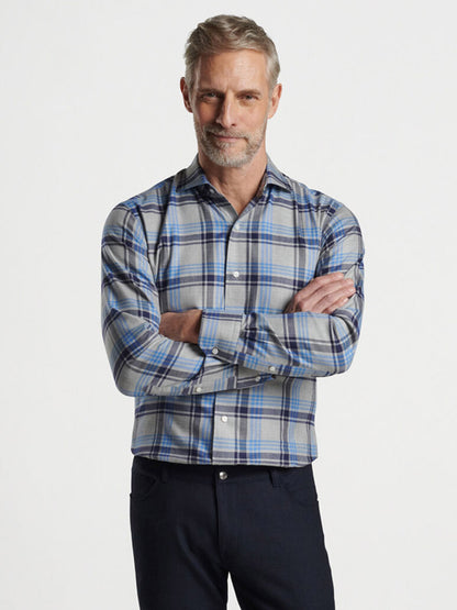 A man with gray hair and a beard is wearing the Peter Millar Coulter Italian Flannel Sport Shirt in Gale Grey, showcasing the classic charm of seasonal flannels. He stands with arms crossed against a plain background, emphasizing the tailored fit.