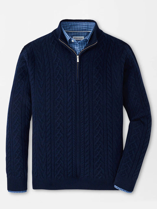 A Peter Millar Crescent Ridge Cable Quarter-Zip Sweater in Navy is layered over a blue and white checkered collared shirt, both displayed flat against a white background.