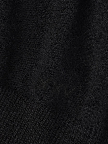 Close-up of a black Peter Millar 25th Anniversary Cashmere Quarter-Zip Sweater with the Roman numeral “XXV” embroidered in matching black thread.