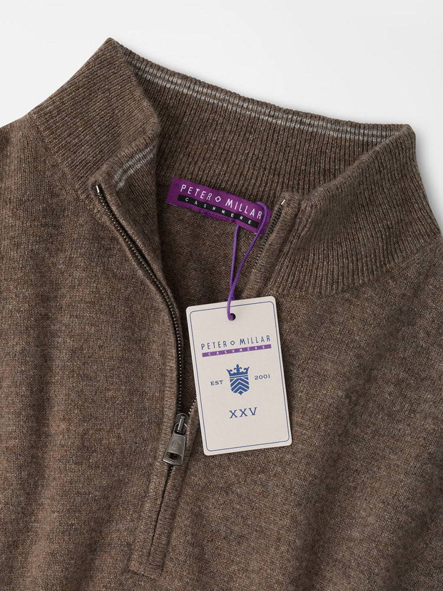 Peter Millar 25th Anniversary Cashmere Quarter-Zip Sweater in Sawgrass, a brown cashmere sweater in a classic fit with a zippered collar and a 25th anniversary hang tag at the neckline.