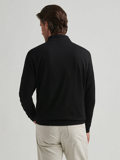 A man stands with his back to the camera, wearing the Peter Millar Crown Comfort Pullover in Black and light-colored pants against a plain background.