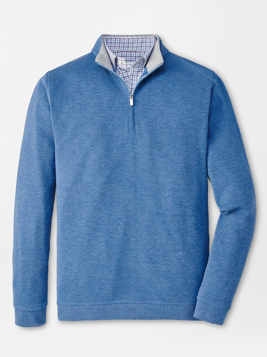 A Peter Millar Crown Comfort Pullover in Astral Blue featuring a white zipper, layered stylishly over a blue and white checkered shirt for a lightweight and fashionable look.