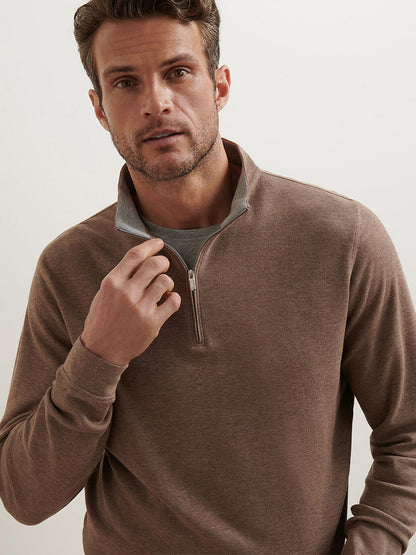 A man wears the Peter Millar Crown Comfort Pullover in Poplar Brown over a gray shirt, standing against a plain light background and looking directly at the camera.