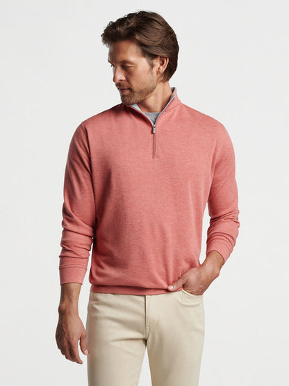 Man wearing a Peter Millar Crown Comfort Pullover in Clay Rose and beige pants.