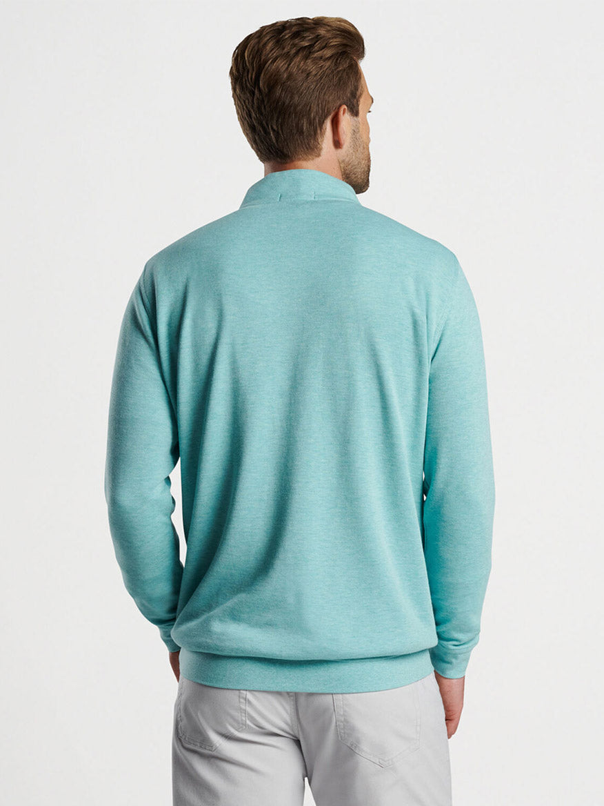 Man wearing a Peter Millar Crown Comfort Pullover in Cloud and grey pants, viewed from behind.