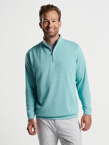 Man in a Peter Millar Crown Comfort Pullover in Cloud smiling at the camera.