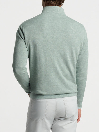 Sentence with product name: Man wearing a Peter Millar Crown Comfort Pullover in Tea Leaf and grey pants viewed from behind.