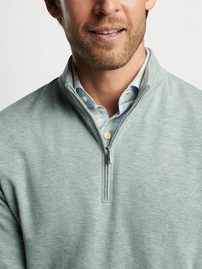 Man wearing a Peter Millar Crown Comfort Pullover in Tea Leaf over a collared shirt.