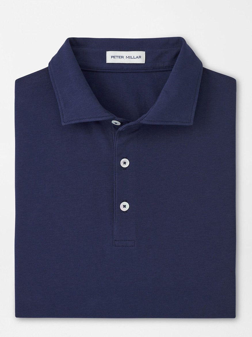 A folded navy Peter Millar Crown Flex Cotton Polo, classic fit with a collar and three buttons, featuring the brand’s label inside the neckline.