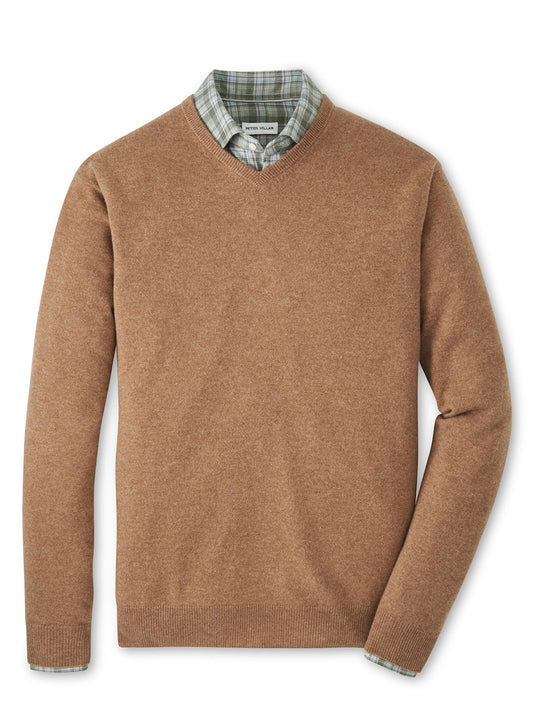 The Peter Millar Crown Heritage Cashmere V-Neck Sweater in British Tan is styled over a green and white plaid collared shirt, both neatly displayed on a white background.