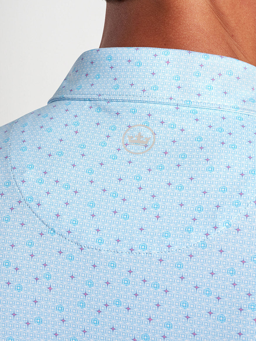 Close-up of the back collar of a Peter Millar Diamond In The Rough Performance Jersey Polo in Blue Frost with a logo embroidery.