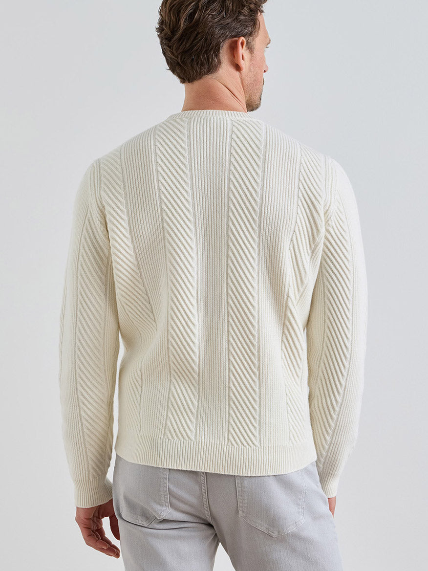 Back view of a man wearing a Peter Millar Dolomite Crewneck Sweater in Almond, a tailored-fit, off-white crewneck featuring a diagonal ribbed pattern.