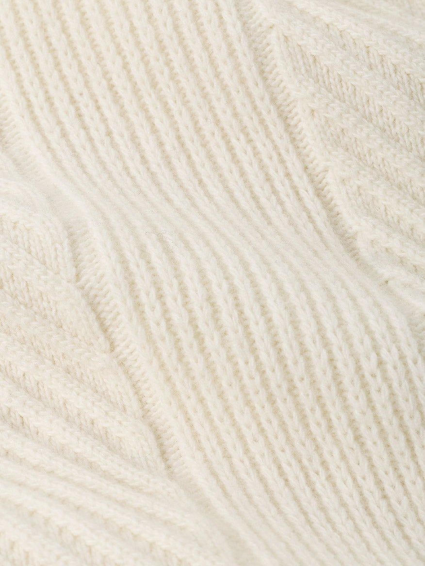 Close-up of a Peter Millar Dolomite Crewneck Sweater in Almond, an off-white, tailored-fit Merino-cashmere sweater in a ribbed knit.