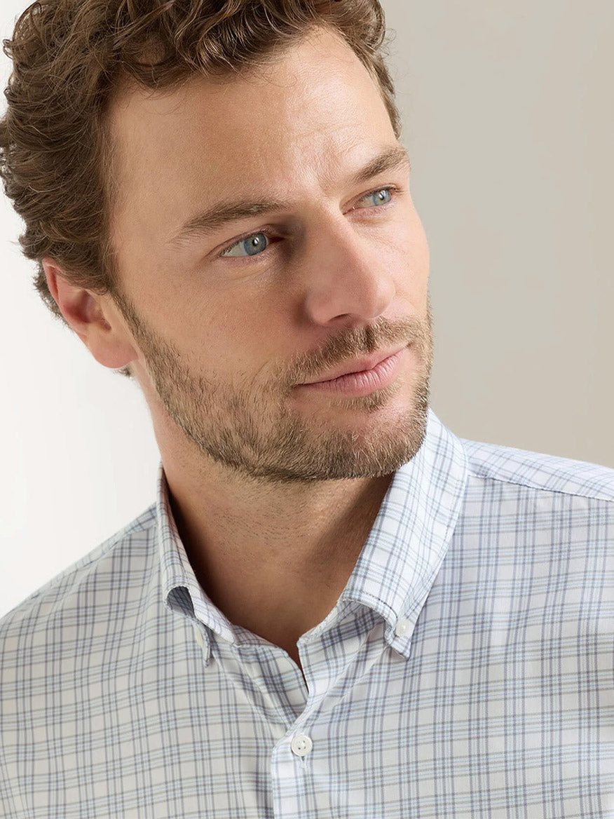 Man with light brown hair and beard wears the Peter Millar Douglas Crown Lite Cotton-Stretch Sport Shirt in Gale Grey, classic fit with checkered design, looking off to the side against a plain background.