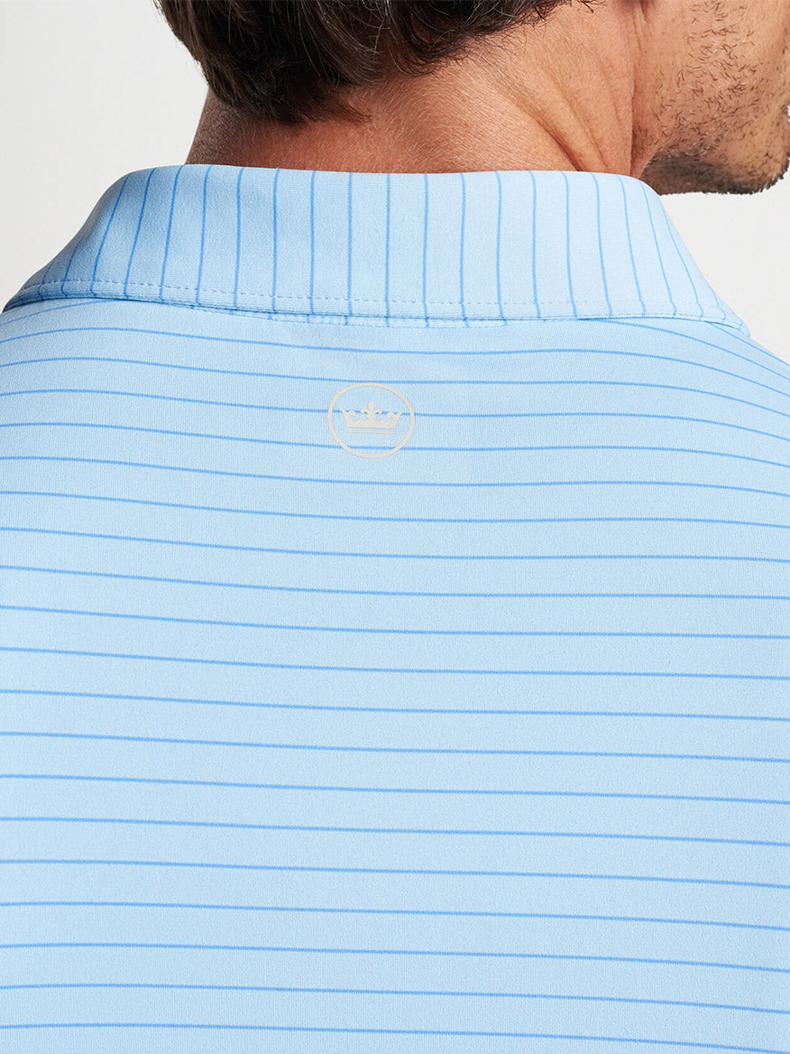 Close-up of the back of a man's light blue striped Peter Millar Duet Performance Jersey Polo in Blue Frost with a logo on the collar.