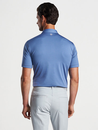 Man wearing a Peter Millar Duet Performance Jersey Polo in Blue Pearl and light gray pants, viewed from behind.