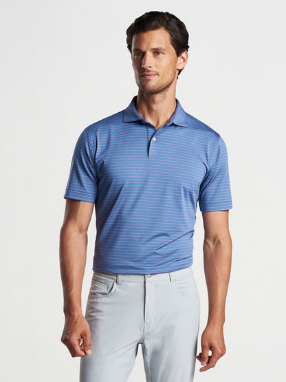 Man wearing a Peter Millar Duet Performance Jersey Polo in Blue Pearl and light gray pants.