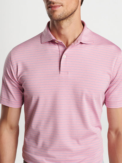 Man wearing a Peter Millar Duet Performance Jersey Polo in Spring Blossom made from performance fabric.