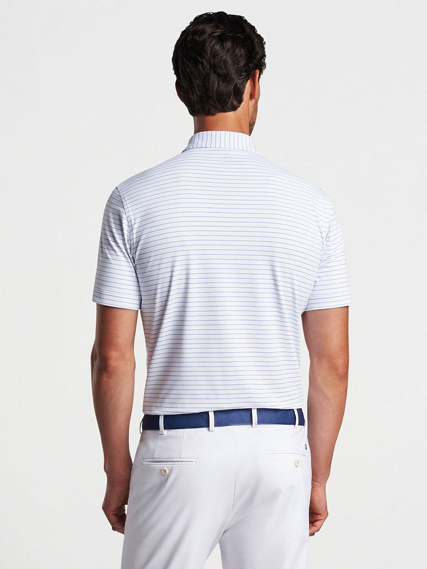 Man wearing a striped Peter Millar Duet Performance Jersey Polo in White and white trousers viewed from the back.