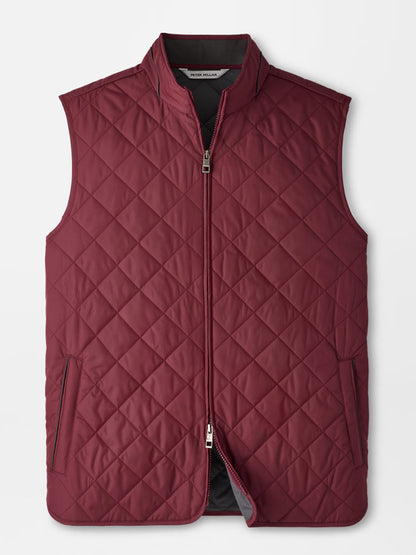 The Peter Millar Essex Vest in Bordeaux is a maroon quilted vest featuring a front zipper, two zippered side pockets, and a stand collar, designed as a stylish windproof layer and shown on a plain white background.