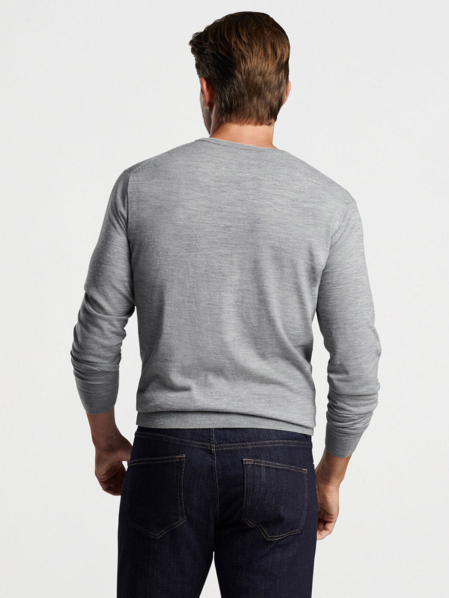Man viewed from the back wearing a Peter Millar Excursionist Flex Crew in Gale Grey and blue jeans.