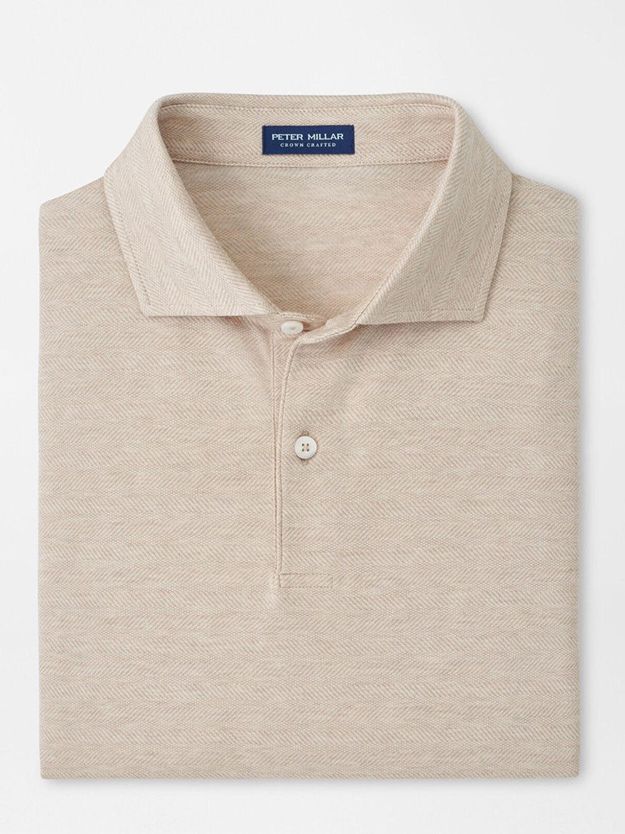 A neatly folded Peter Millar Excursionist Flex Herringbone Knit Polo in Truffle, featuring a classic collar and two-button placket.