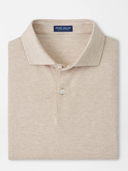 A neatly folded Peter Millar Excursionist Flex Herringbone Knit Polo in Truffle, featuring a classic collar and two-button placket.
