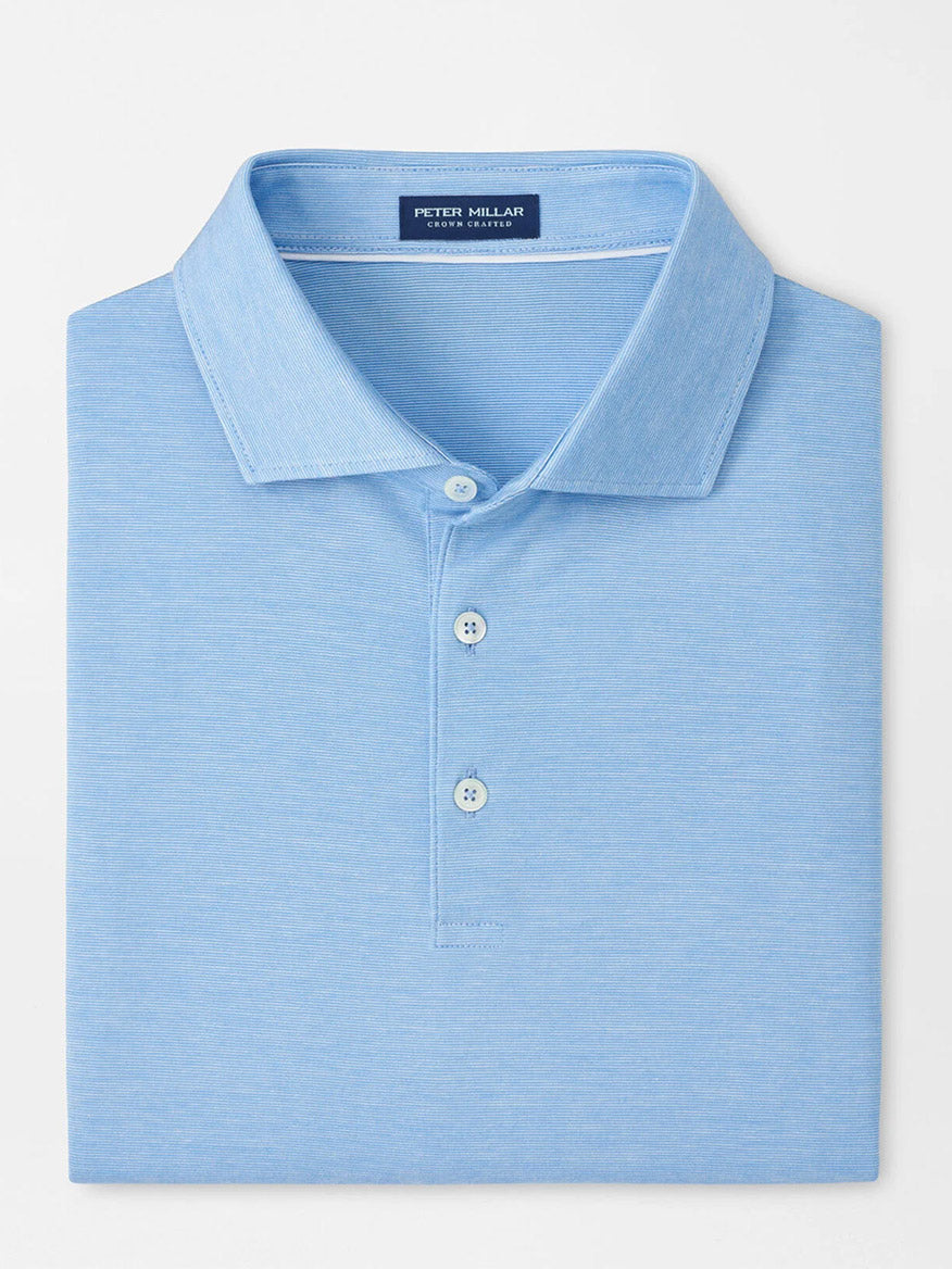 A neatly folded Peter Millar Excursionist Flex Polo in Blue Topaz with a collar, three buttons, and "Peter Millar" label inside the neckline, crafted from soft cotton jersey knit.