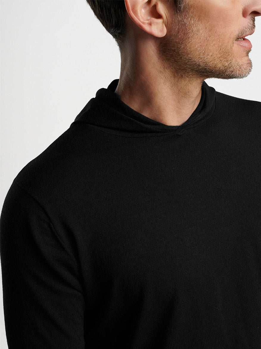 Side view of a man wearing a Peter Millar Excursionist Flex Popover Hoodie in Black.