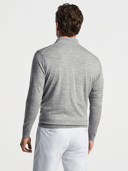 Man wearing a Peter Millar Excursionist Flex Quarter-Zip in Gale Grey long-sleeve shirt and white pants, viewed from the back.