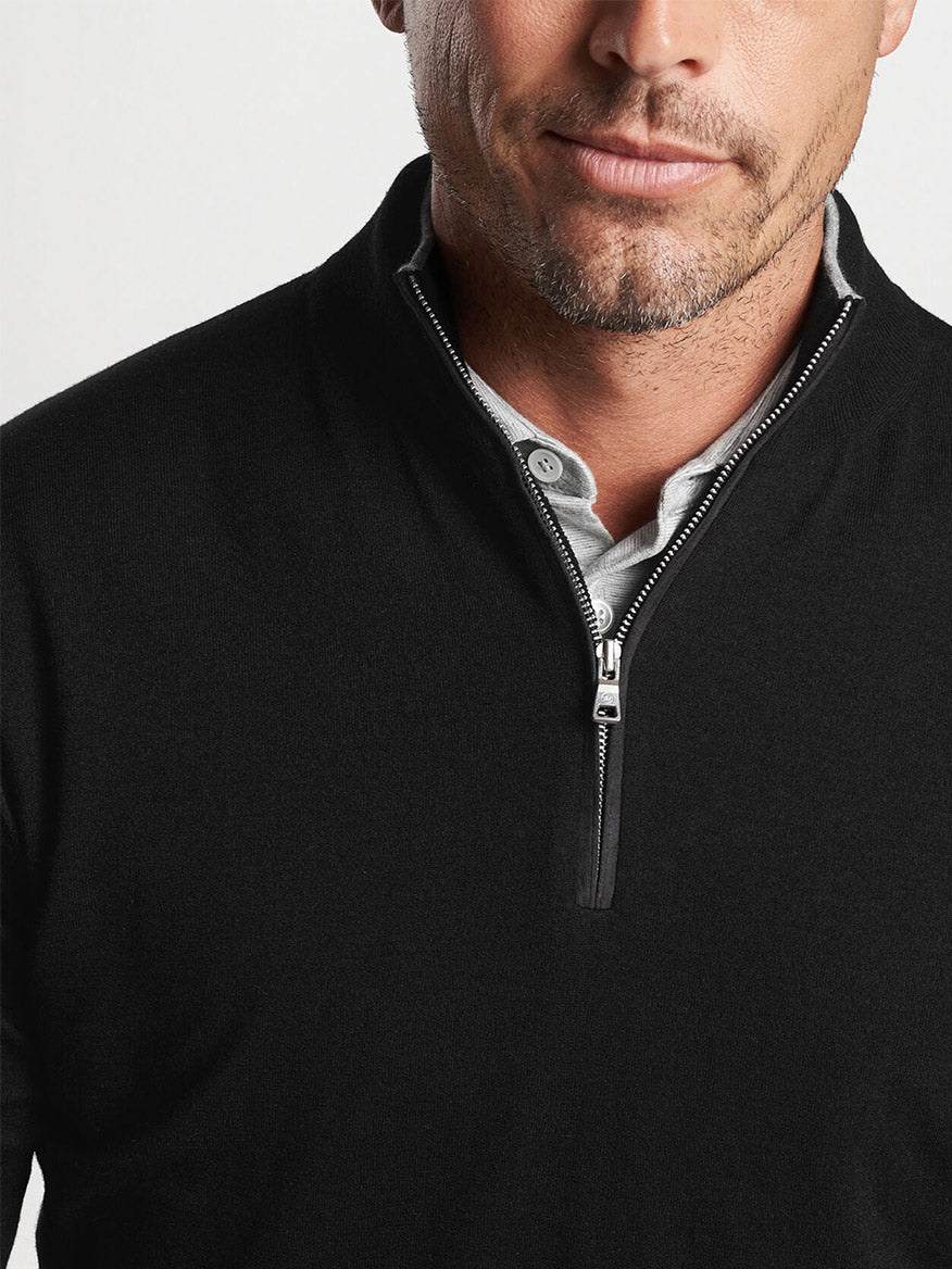Man wearing a Peter Millar Excursionist Flex Quarter-Zip in Black, crafted from performance yarn for optimal shape retention.