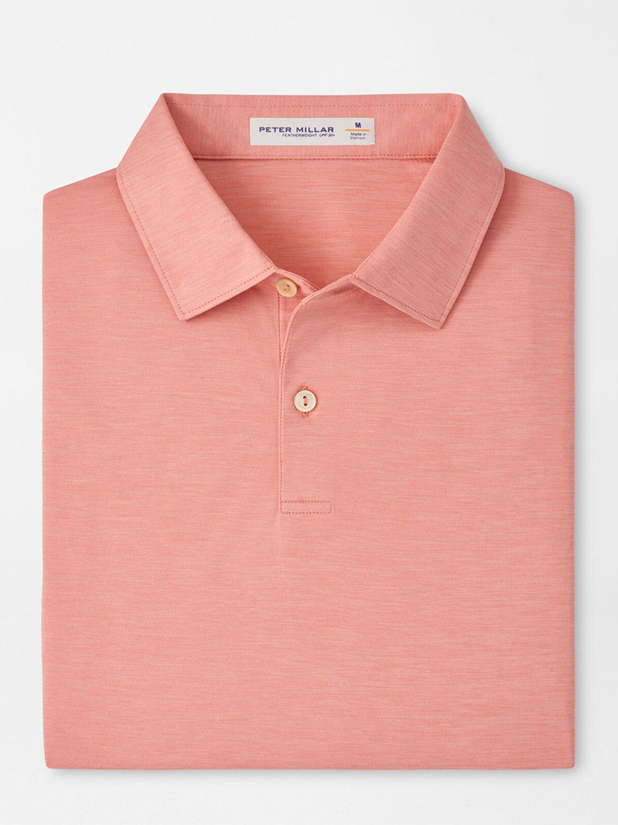 A neatly folded Peter Millar Featherweight Mélange Performance Polo in Venetian Pink, featuring a collar, two buttons, and UPF 50+ sun protection, displayed against a plain white background.