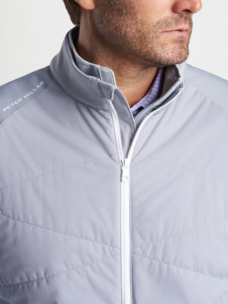 Man wearing a Peter Millar Fuse Hybrid Vest in Gale Grey over a collared shirt.