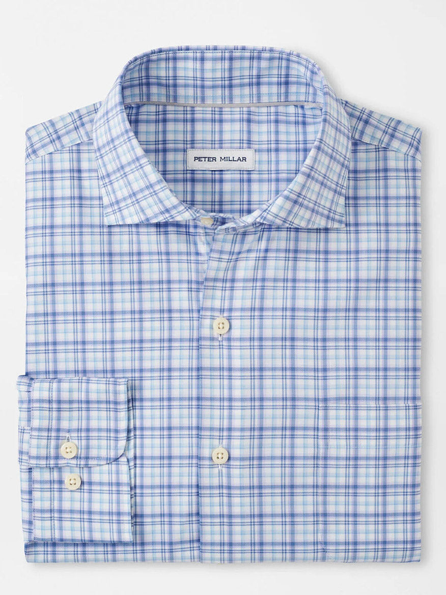 A folded sport shirt featuring a blue and white plaid pattern and buttons, with the "Peter Millar" label, crafted from easy-care cotton-stretch fabric in a classic fit.