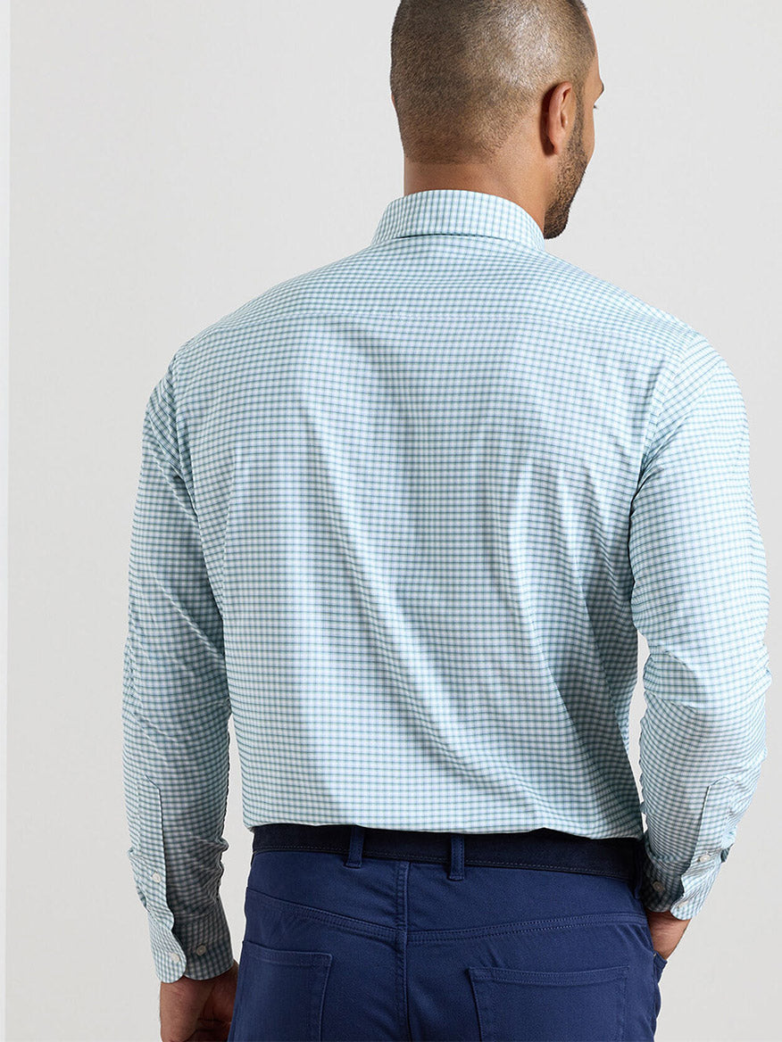 A man is shown from the back wearing the Peter Millar Gregory Performance Twill Sport Shirt in Windsor Blue and dark blue trousers.