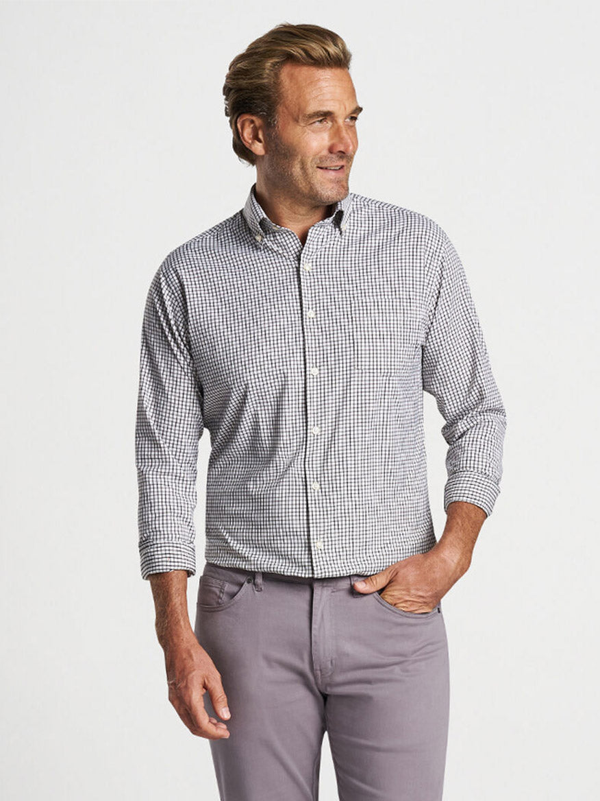 Sentence with product name: A man posing in a Peter Millar Hanford Performance Twill Sport Shirt in Cottage Blue and light purple trousers.