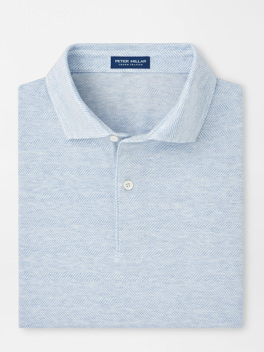 The Peter Millar Harris Herringbone Knit Polo in Blue Frost is a light blue, cotton-blend polo with a herringbone pattern and tailored fit, folded neatly.