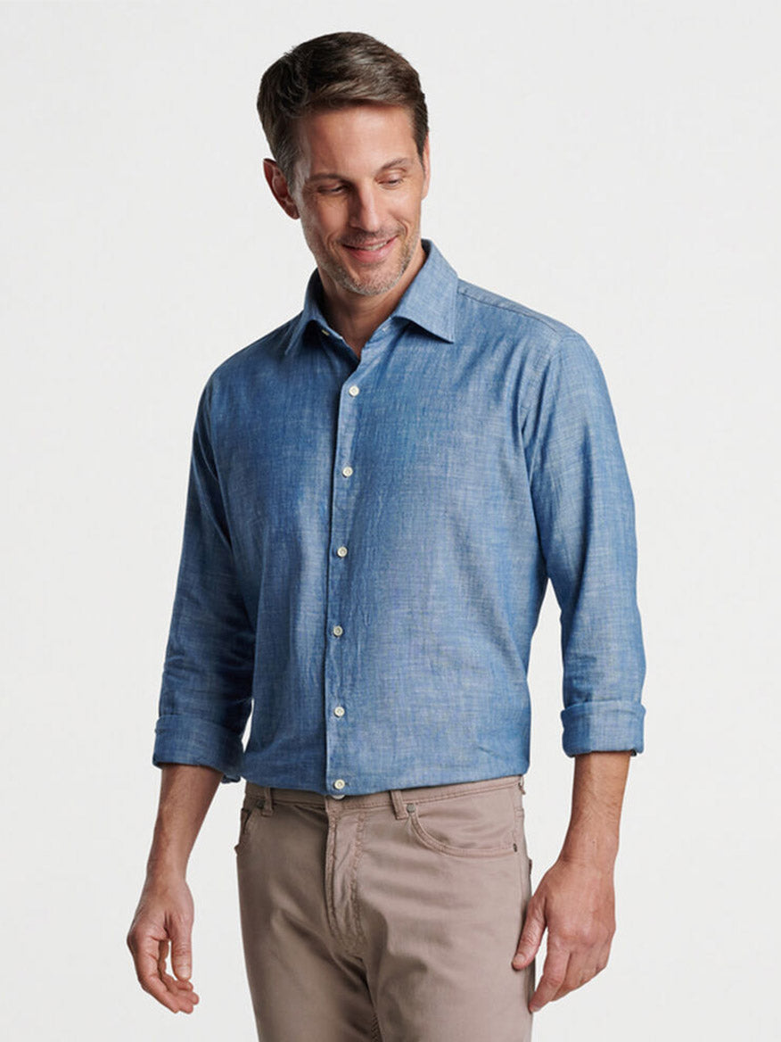 Man smiling and posing in a tailored fit, Peter Millar Japanese Selvedge Sport Shirt in Light Chambray and khaki pants.