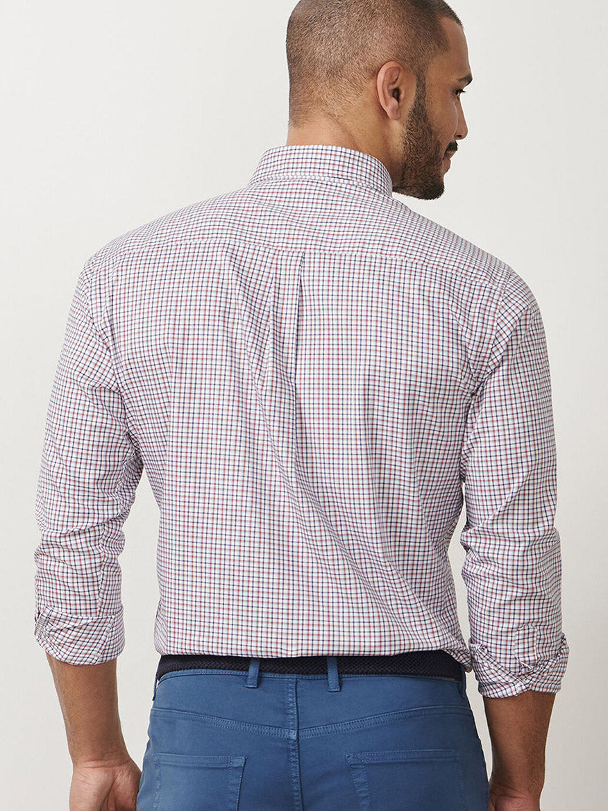 A man with short hair stands facing away, wearing the Peter Millar Julian Crown Lite Cotton-Stretch Shirt in Navy and blue pants.