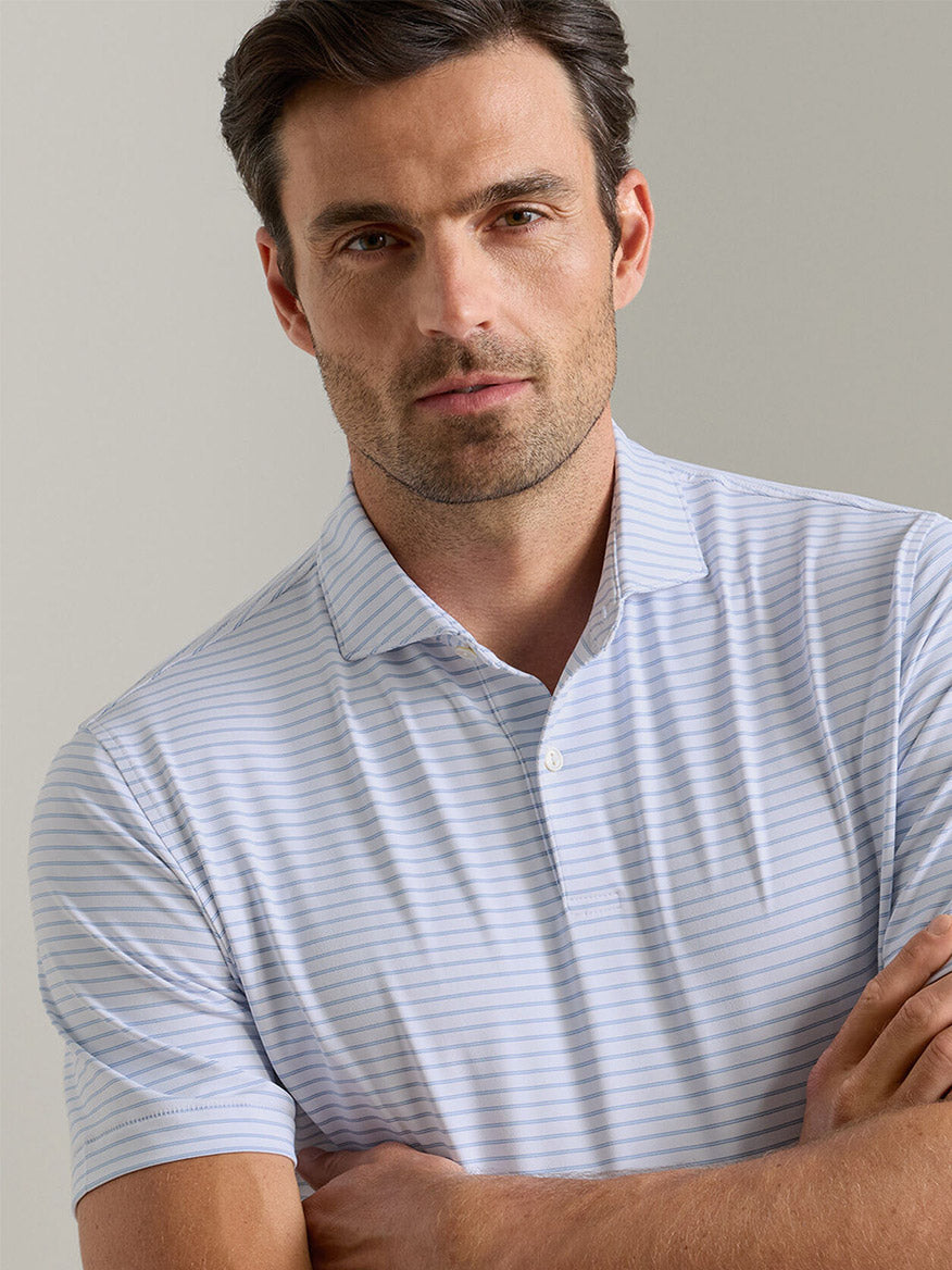 A man with short brown hair and light facial hair wears the Peter Millar Keynote Performance Jersey Polo in White, standing against a plain light background.