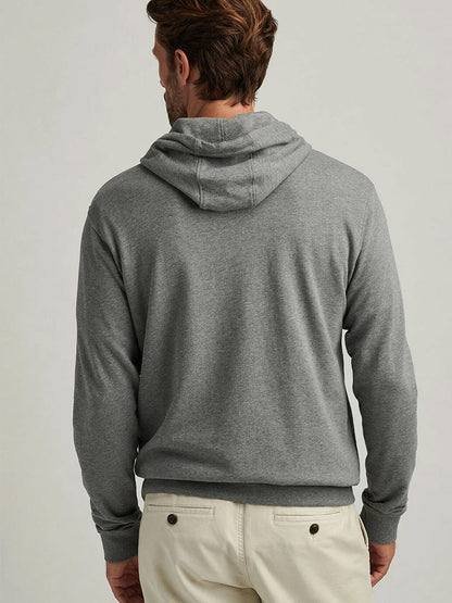 A person is pictured from the back in the Peter Millar Lava Wash Hoodie in Gale Grey and light-colored pants, set against a plain background to showcase its super-soft cotton-modal comfort for everyday wear.