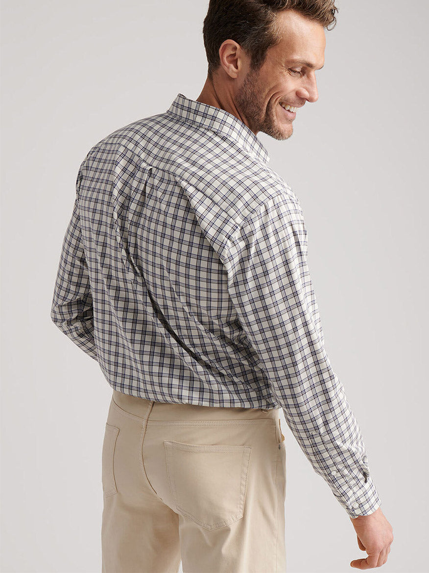 A man stands with his back to the camera, wearing the Peter Millar Lenox Crown Lite Cotton-Stretch Sport Shirt in Winter Ivory and light-colored pants against a plain background.