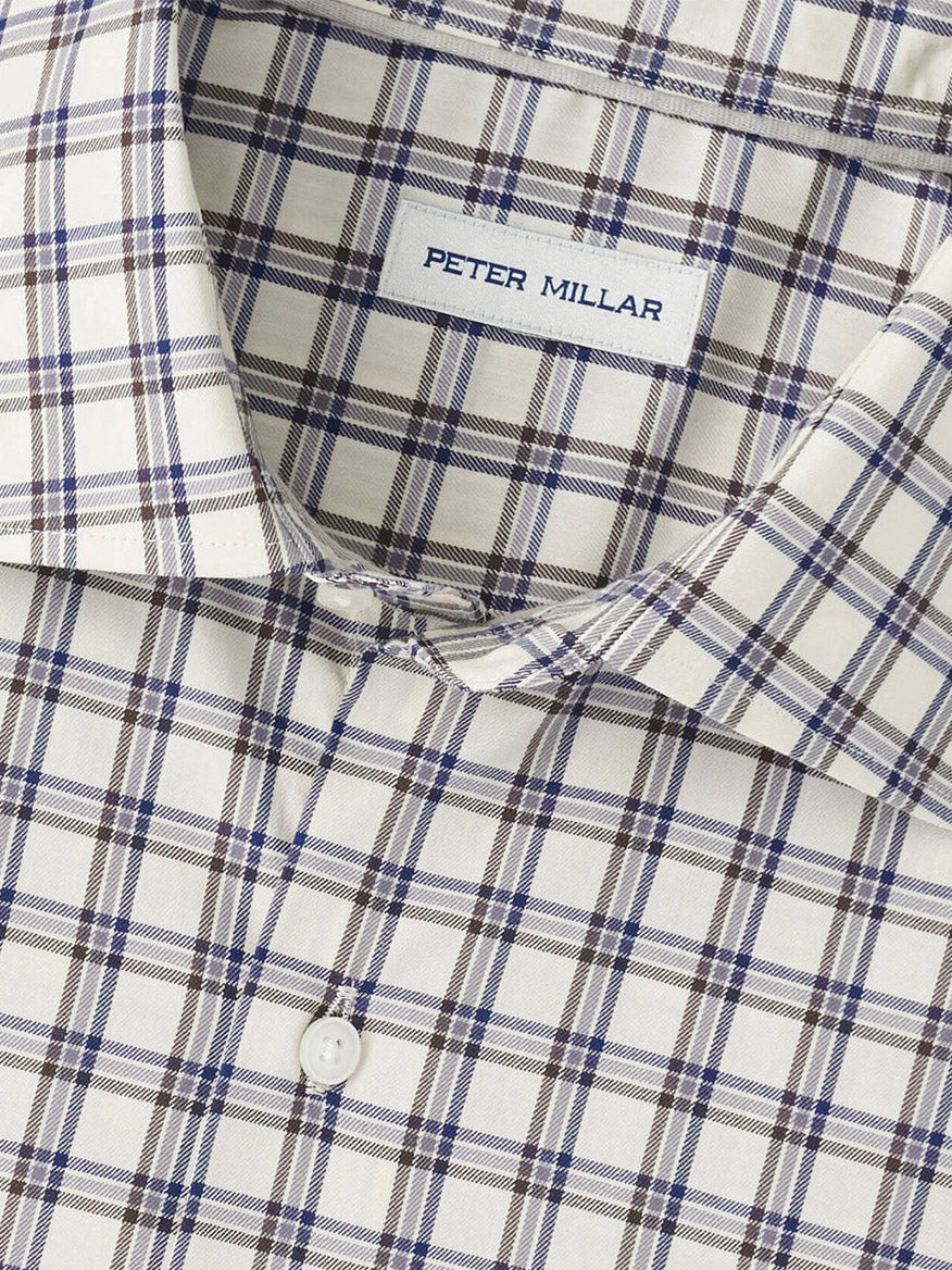 Close-up of the Peter Millar Lenox Crown Lite Cotton-Stretch Sport Shirt in Winter Ivory featuring a beige, blue, and brown plaid pattern with white buttons and made from easy-care cotton-stretch fabric.