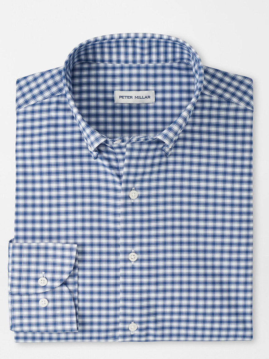 A folded Peter Millar Lewis Performance Twill Sport Shirt in Windsor Blue, featuring a blue and white checkered pattern and a visible label inside the collar.