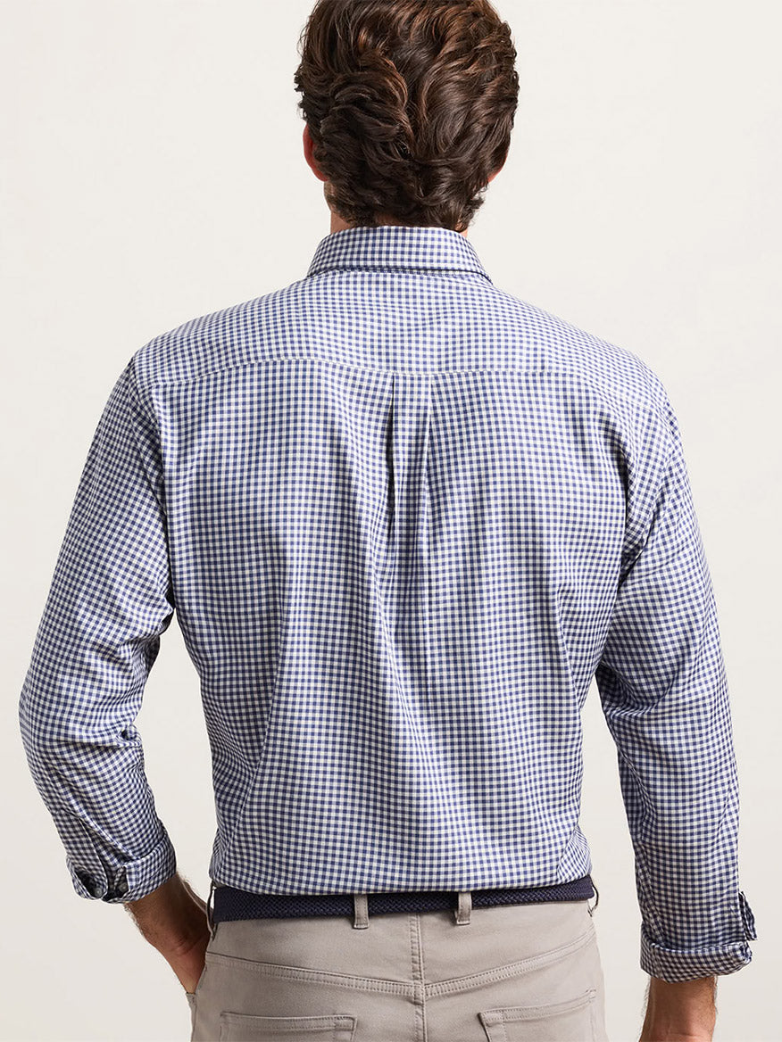 Back view of a man wearing a Peter Millar Liam Crown Soft Twill Sport Shirt in Navy with light-colored trousers.