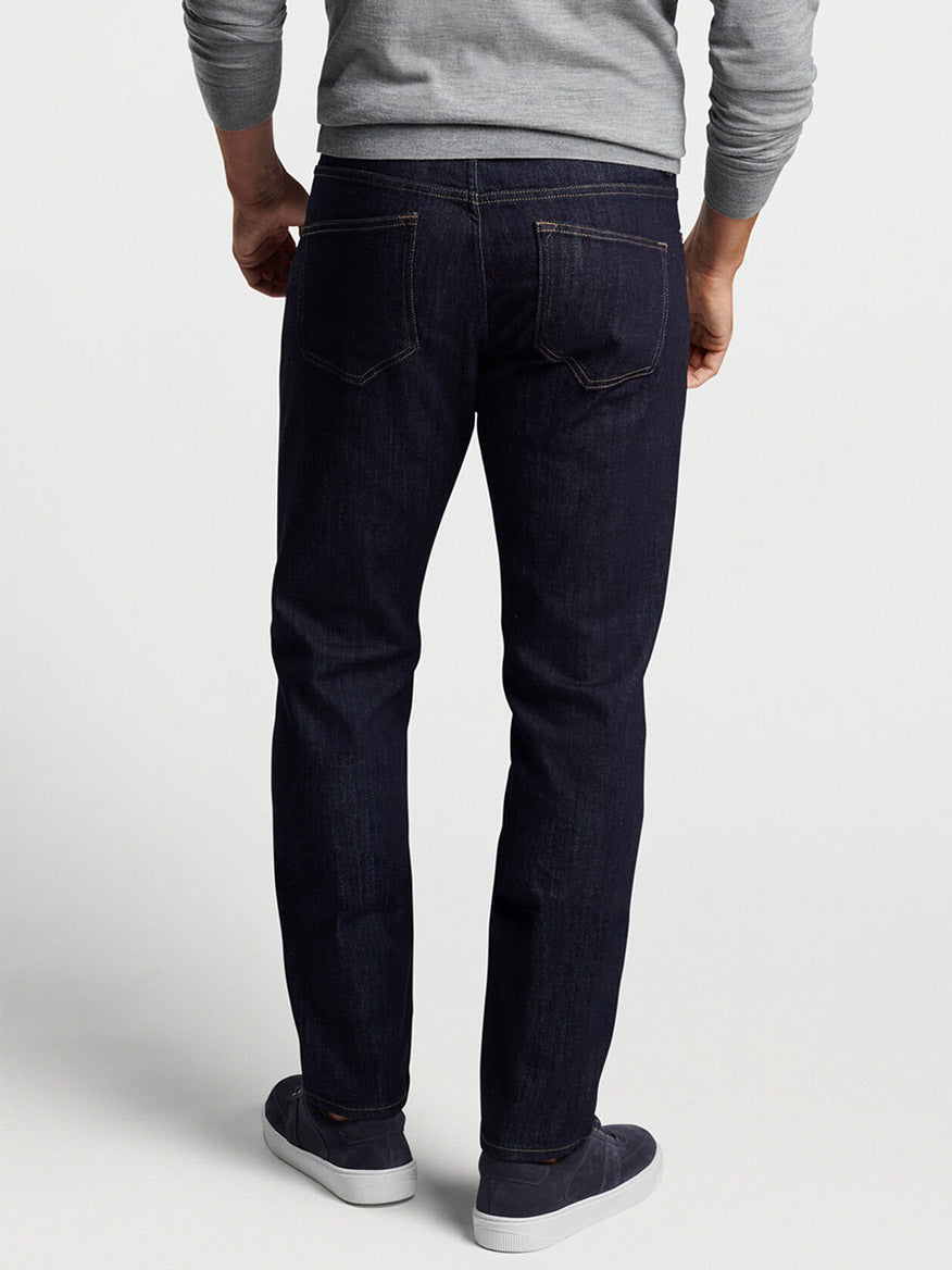 The back of a man wearing Peter Millar Vintage Washed Five-Pocket Denim in Dark Indigo and a sweater.