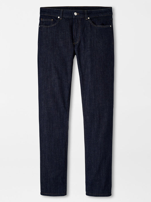 A pair of Peter Millar Vintage Washed Five-Pocket Denim in Dark Indigo jeans displayed against a white background.