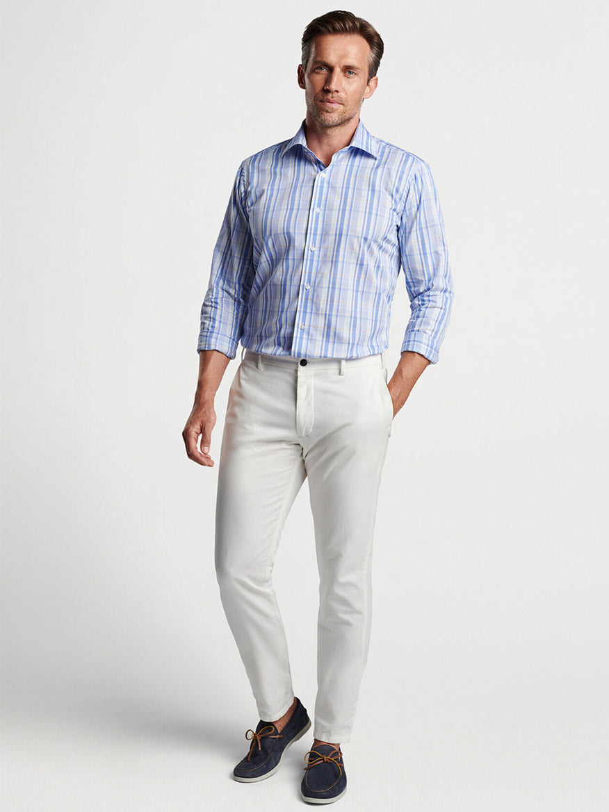 Man modeling a Peter Millar Marcel Cotton Sport Shirt in Cascade Blue and beige cotton poplin trousers.
