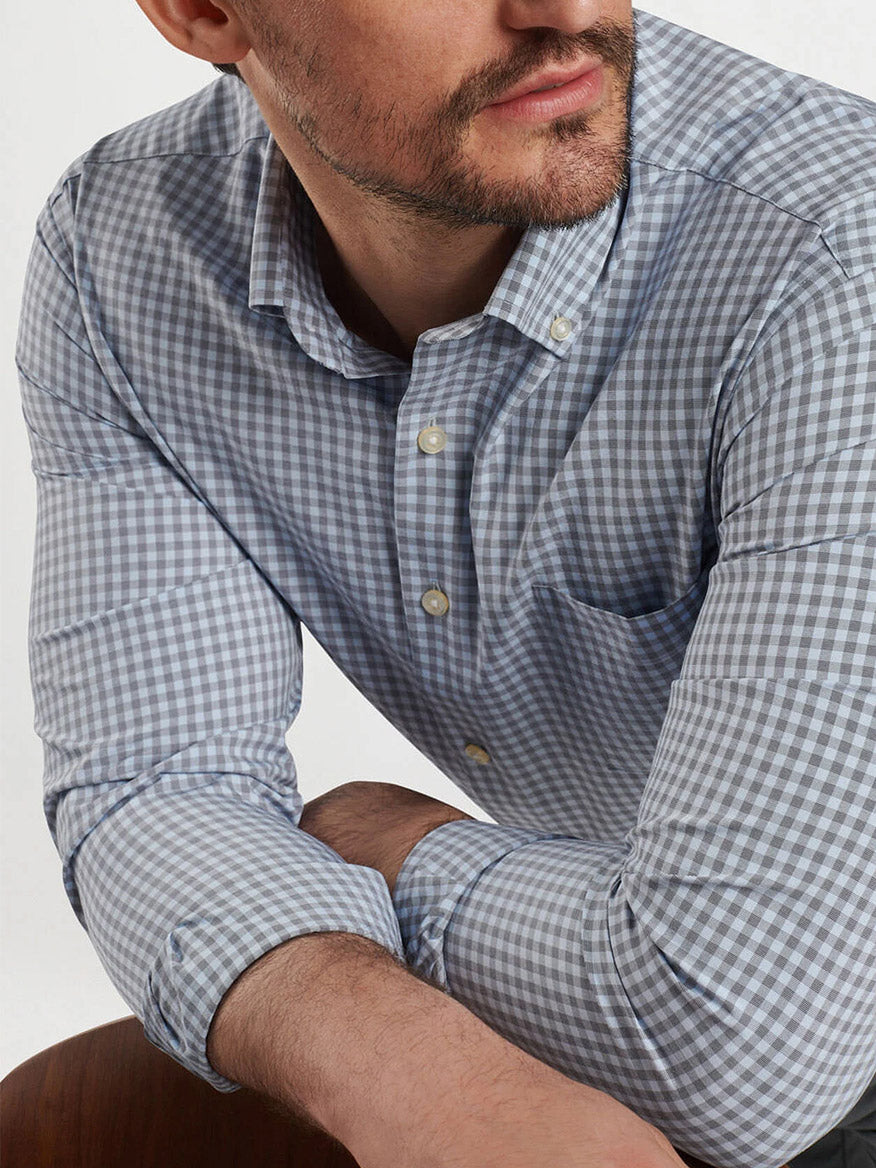 Close-up of a man with a short beard wearing the Peter Millar Murray Performance Poplin Sport Shirt in Navy, his arms crossed and resting on a surface.