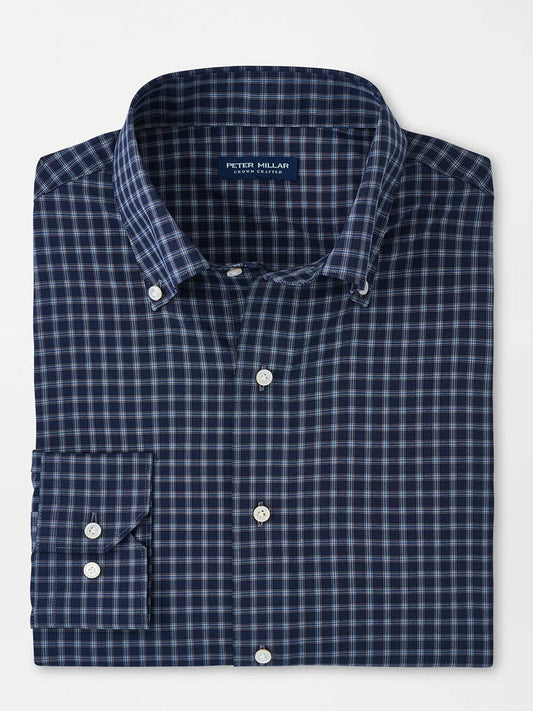 A folded Peter Millar Orton Performance Poplin Sport Shirt in Navy, featuring a dark blue and white checkered pattern, button-down design with a collar and front pocket.